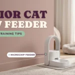 White microchip pet feeder on a mat in a bedroom with a grey senior cat sitting nearby, against a dusty rose wall